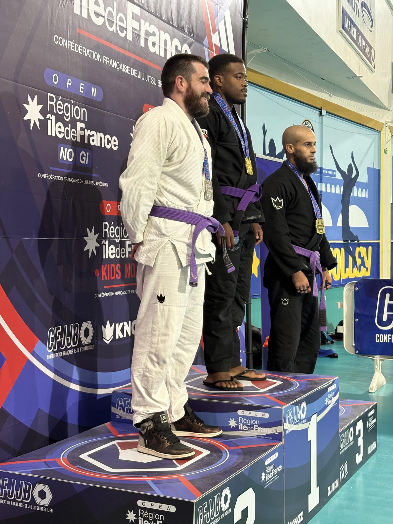 Podium jiu-jitsu brésilien avec trois compétiteurs médaillés