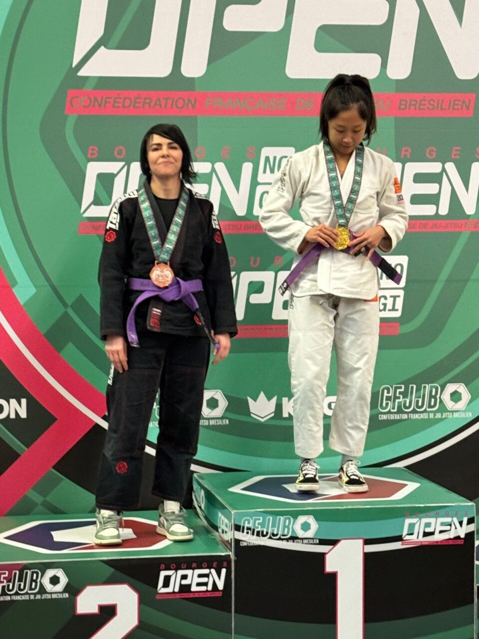 Deux femmes sur podium jiu-jitsu brésilien avec médailles