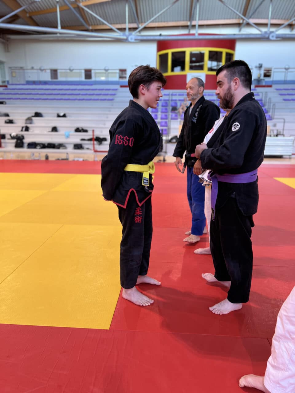 Jeune judoka ceinture jaune face à un instructeur ceinture violette