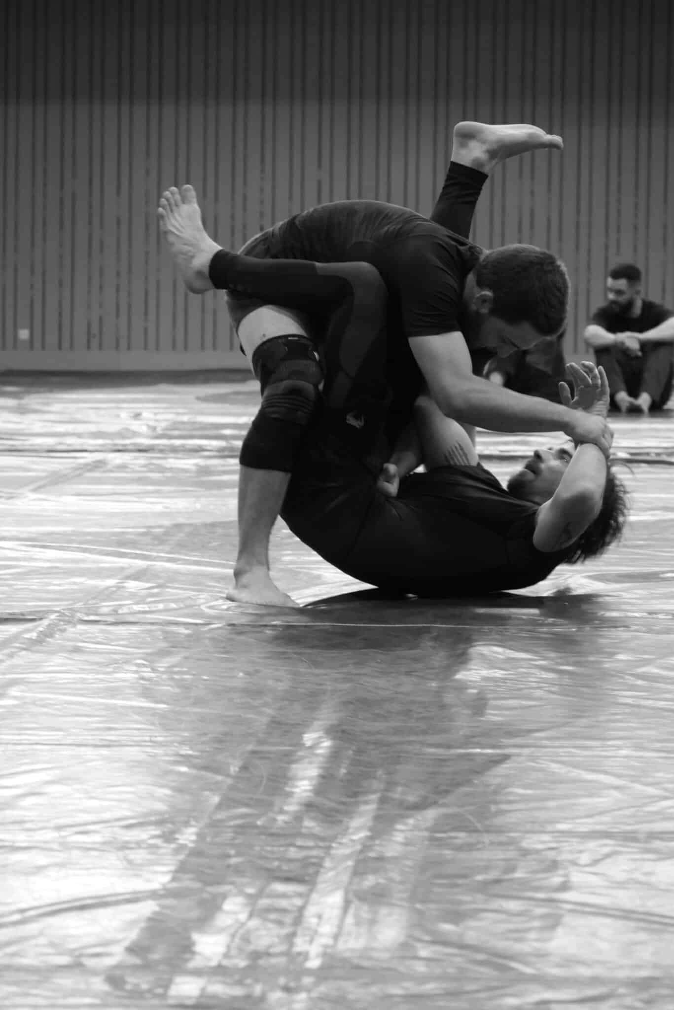 Deux combattants en sparring de jiu-jitsu brésilien au sol